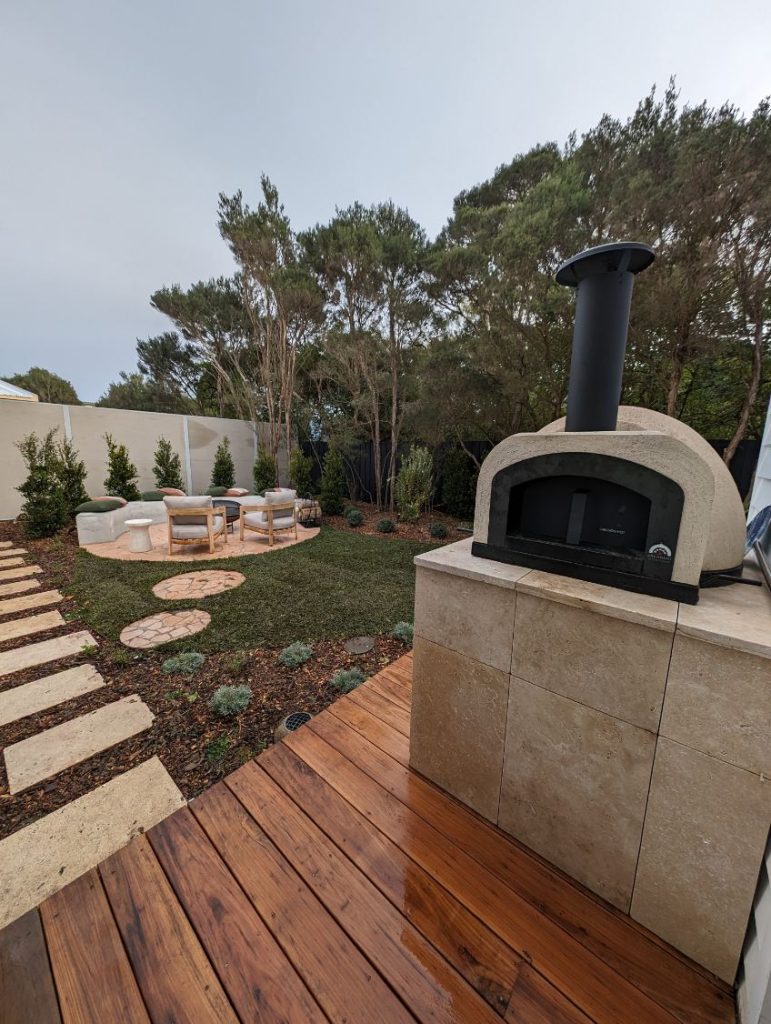 Pizza oven located on a wooden deck, perfect for enjoying outdoor pizza-making.