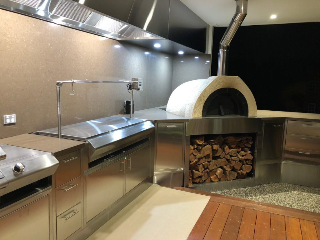 Charming outdoor kitchen equipped with a traditional wood-burning oven, ideal for cooking and entertaining in nature.